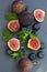 Fresh figs with mint and blueberries. Beautifulf berry, fruit background, frame for design with copy space