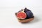 Fresh figs in a wooden bowl on a white background. Food Photo. Purple Fig with red seeds close up. Side view