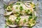 Fresh fish, cod fillets with parsley, lemon slices, onion and spices prepared for baking on parchment paper