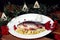 Fresh fish on a white plate with pieces of quince and cranberries on a wooden background with juniper branches and viburnum