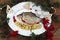 Fresh fish on a white plate with pieces of quince and cranberries on a wooden background with juniper branches and viburnum