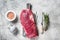 Fresh Flank or flap raw beef steak on wooden board with herbs. Gray background. Top view