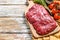 Fresh flank steak on a chopping Board. White background. Top view. Copy space