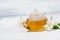 Fresh flavored green tea in a glass teapot on white background