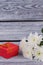 Fresh flowers and present box on wooden background.