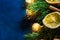 Fresh fluffy fir tree branches dried orange slices cinnamon sticks glittering golden garland lights on dark blue backdrop