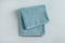 Fresh fluffy folded towel on grey background, top view.