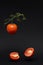 fresh flying tomatoes on a branch in the air. healthy diet. vegetarian food. fresh vegetables on a dark background.