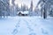 fresh footprints leading up to a secluded forest lodge in snow