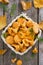 Fresh forest chanterelle mushrooms in a basket, top view