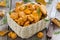 Fresh forest chanterelle mushrooms in a basket on wooden table