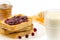 Fresh french toast with honey and jam on a white plate with berries on a white background.