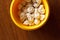 Fresh frozen ravioli in a yellow plate standing on a wooden table