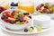 Fresh fruit and berry salad and cream for breakfast, close-up