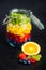 Fresh fruit in front of glass jar full of colorful fruits