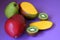 Fresh fruit, juicy mango, kiwi cut in half, large pear, colors, purple background, vitamins, sweet nature