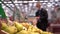 Fresh fruit in the supermarket close-up . Shopper picks up a delicious fresh ingredient for cooking.