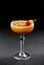 Fresh fruit tropic cocktail with peach, orange in tall glass over dark background.