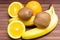 Fresh fruits banana, kiwi, orange isolated on wooden background.