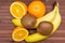 Fresh fruits banana, kiwi, orange isolated on wooden background. Healthy food. A mix of fresh fruit. Group of citrus fruits.