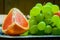 Fresh fruits, grapefruit with grapes on a metal plate