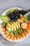 Fresh fruits on a plate. Tropical fruits assortment on a white plate. top view. Copy space