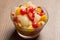 fresh fruits salad on glass bowl with wooden background