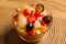 fresh fruits salad on glass bowl with wooden background