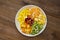 Fresh fruits salad - mango, citrus, kiwi fruit, plum and persimmon. Wooden background, flat lay, top view healthy food. Smoothie