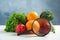 Fresh fruits, vegetables and magnifying glass on white table against light blue background. Food poisoning concept