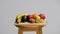 Fresh fruits on wooden stool against white background