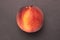 Fresh fuzzy peach on grey stone