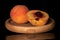 Fresh fuzzy peach isolated on black glass