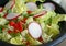 Fresh garden salad with diced red pepper, green onions, sliced radish and chopped romaine lettuce