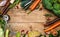 Fresh garden vegetables ingredients for broth or soup cooking on rustic wooden background, top view.