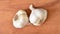 Fresh garlic bulbs dancing on a wooden cutting board