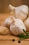 Fresh garlic with spices on a wooden background, thyme and rosemary. Culinary background, ingredients for marinade, close up.