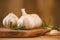 Fresh garlic with spices on a wooden background, thyme and rosemary. Culinary background, ingredients for marinade, closeup