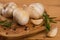 Fresh garlic with spices on a wooden background, thyme and rosemary. Culinary background, ingredients for marinade, closeup