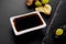 Fresh ginger with a grape, soy sauce for sushi. Black shale background.