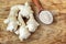 Fresh ginger root and ginger powder in the spoon on wooden background, raw material for cooking