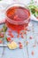 Fresh goji berries tea in a glass cup on a wooden table