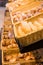 Fresh golden breads with melted cheese wrapped in plastic wrap in wicker basket in bread department of supermarket