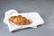 Fresh golden croissant lies on a white linen napkin. Gray background, copy space