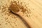 Fresh granules of instant coffee grains, in wooden spoon, on wooden background