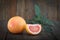 Fresh grapefruits with leaves on wooden background