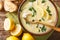 Fresh greek lemon soup with chicken and orzo paste close-up in a bowl. Horizontal top view