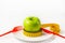 Fresh green apple with a yellow tape measure on a plate. Weight loss concept