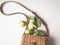 Fresh green apples with leaves in wicker straw brown bag on white background. Top view. Copy space