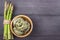 Fresh green asparagus and fettuccine italian pasta in bowl on wooden rustic background